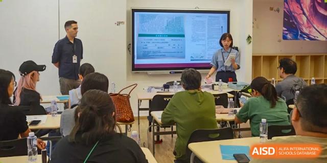 A teacher is presenting information on a smart board to a class at Shenyang International School.