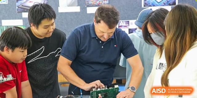 A teacher is working on a circuit board at Shenyang International School.