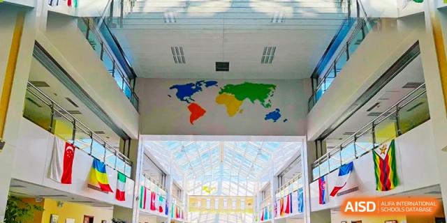 A ceiling is painted with a world map and a glass atrium is below it at Shenyang International School.