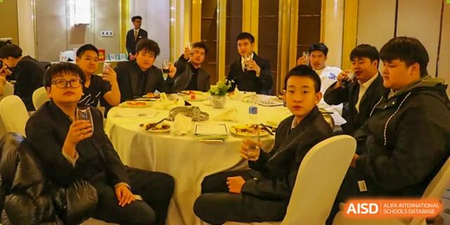 Students are seated at a banquet table at Shenyang International School.