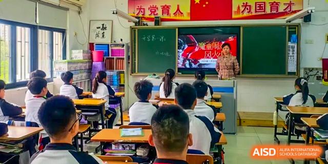 Shenzhen Yaohua Experimental School students seated at their desks, facing the front of a classroom with a bright digital screen displaying content.