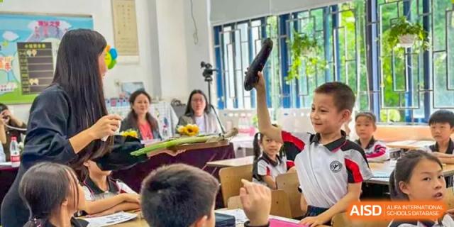 Shenzhen Yaohua Experimental School students gathered around a table for a hands-on learning activity in a classroom.
