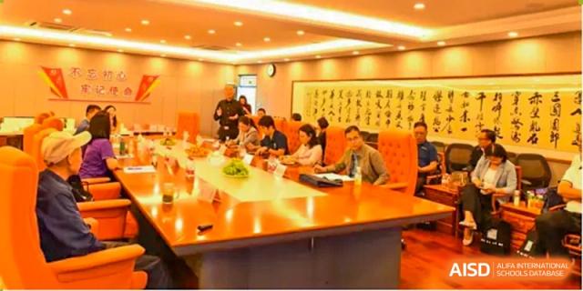 A group of Shenzhen Yaohua Experimental School teachers and administrators seated around a conference table during a meeting.