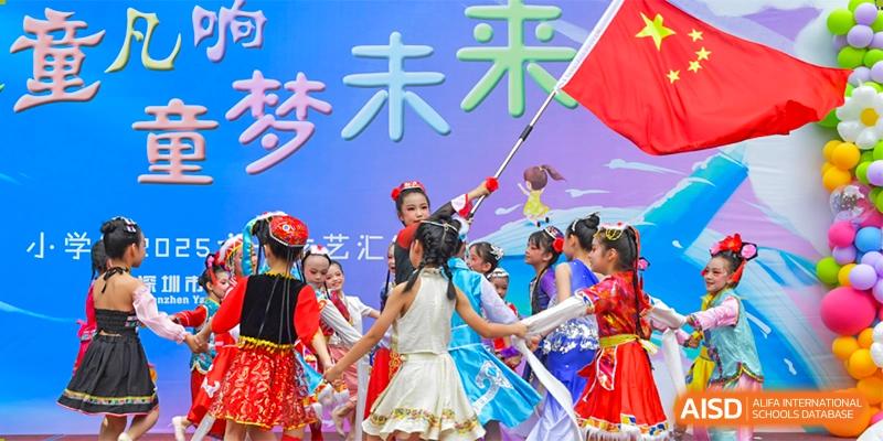 Shenzhen Yaohua Experimental School students performing a colorful cultural dance on a stage during an event.
