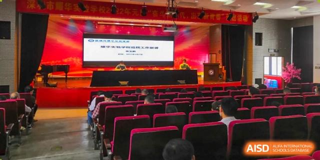 An auditorium full of seated Shenzhen Yaohua Experimental School students and staff during a formal school meeting or conference.