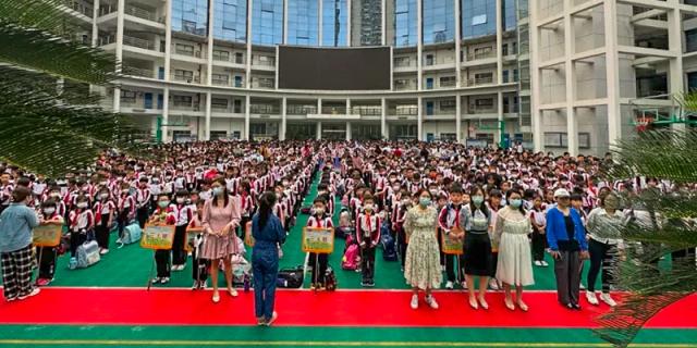 A large assembly of Shenzhen Yaohua Experimental School students gathered on a sports ground for an outdoor school event.