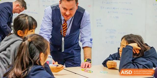 A teacher assisting a student with a science experiment, SPGS International School Chengdu