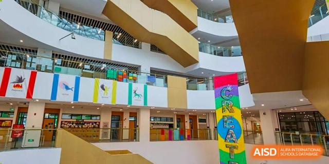 A view of the atrium and multi-story interior architecture of SPGS International School Chengdu, showing colorful walls and a dynamic, modern design.