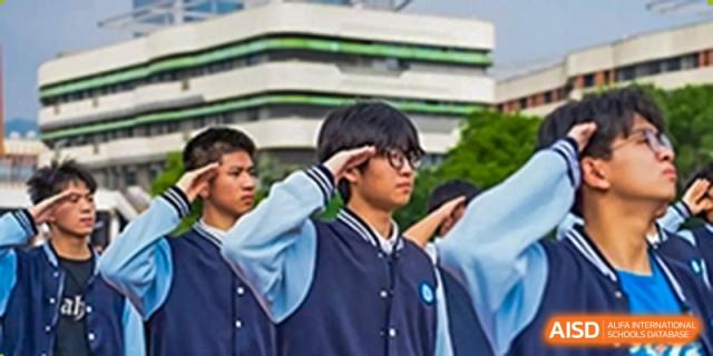A student in a blue and white school uniform saluting at Huzhou South Taihu Bilingual School.
