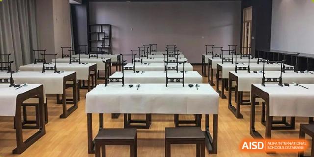 A classroom with desks and chairs, possibly for calligraphy or art, at Huzhou South Taihu Bilingual School.
