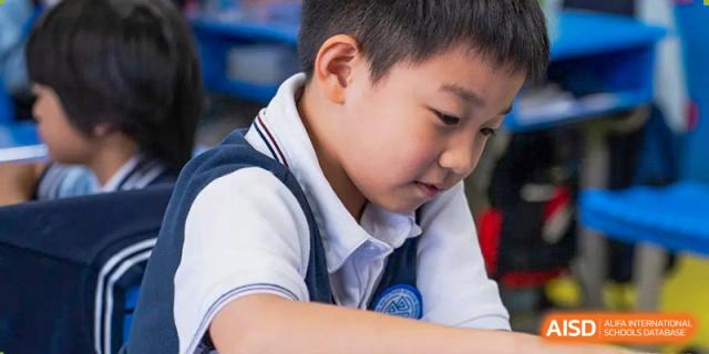 A close-up of a student looking down at their work at Huzhou South Taihu Bilingual School.