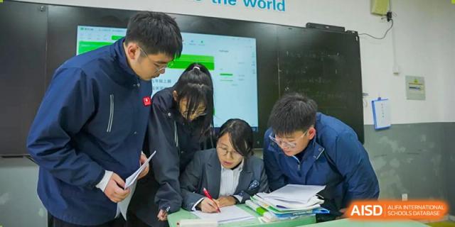 Students looking at a screen or a teacher's presentation at Huzhou South Taihu Bilingual School.