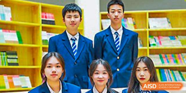 A group of students in school uniforms posing for a photo at Huzhou South Taihu Bilingual School.
