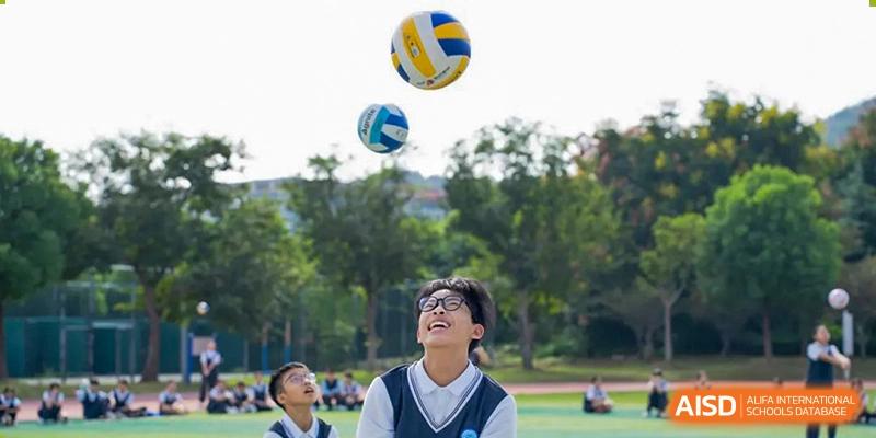 A group of students playing volleyball outdoors at Huzhou South Taihu Bilingual School.