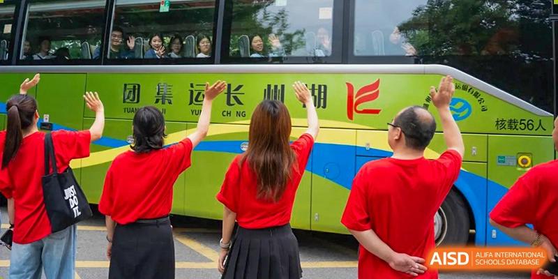 A student waving at people on a school bus at Huzhou South Taihu Bilingual School.