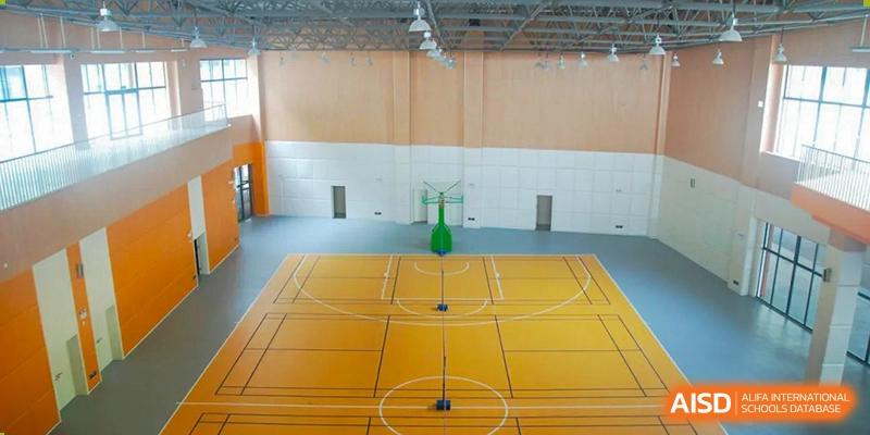 An indoor basketball court inside a gymnasium at Huzhou South Taihu Bilingual School.