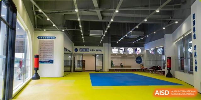 An indoor gym or sports facility with a blue and yellow floor at Huzhou South Taihu Bilingual School.