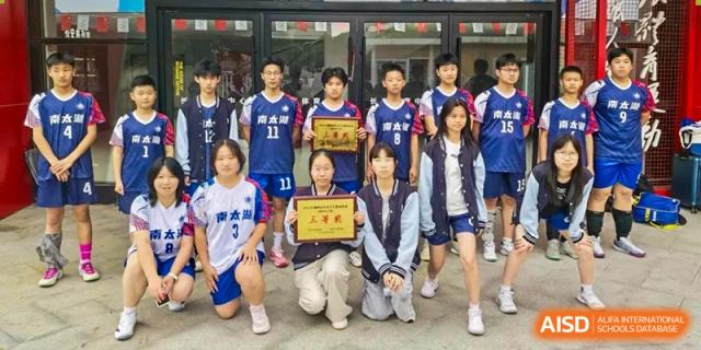 Students holding a certificate, posing for a group photo at Huzhou South Taihu Bilingual School.