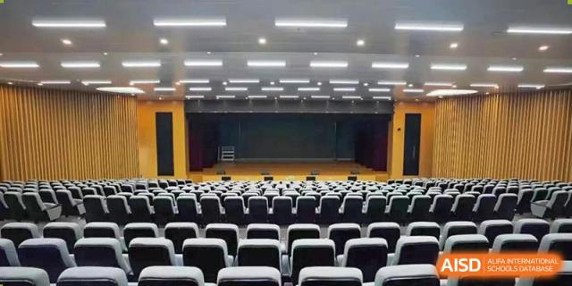An empty auditorium with rows of seats at Huzhou South Taihu Bilingual School.