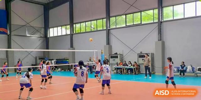 Students playing volleyball in an indoor gym at Huzhou South Taihu Bilingual School.