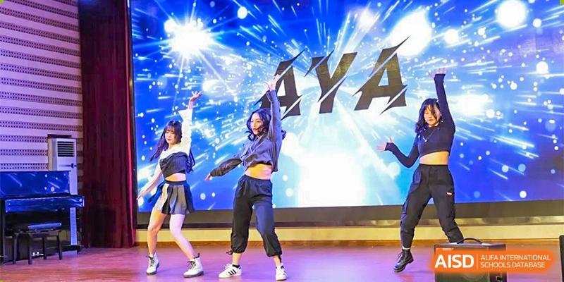 A student from The First High School of Changsha, Hunan performing a modern dance on a bright stage with a dynamic background.