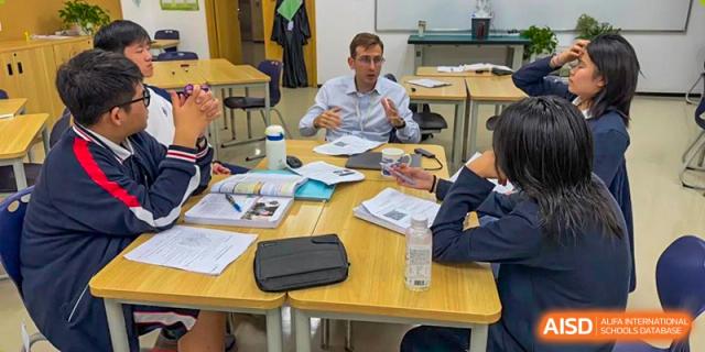BASIS International School Nanjing students collaborating on a group project at a table.