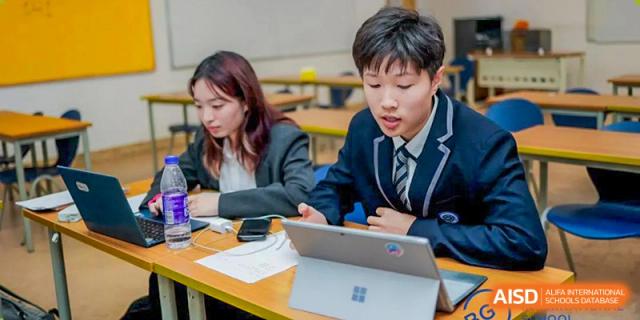 A BASIS International School Nanjing student using a laptop in a classroom.