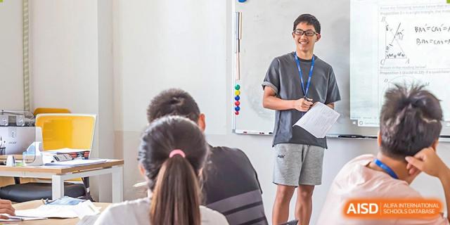 An instructor talking to BASIS International School Nanjing students in a classroom.