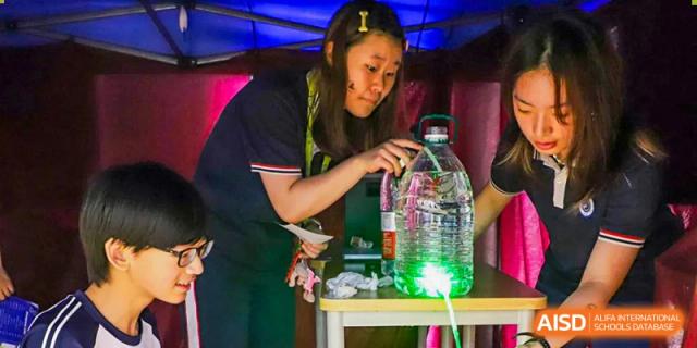 A BASIS International School Nanjing student working on a science experiment with glowing liquids.