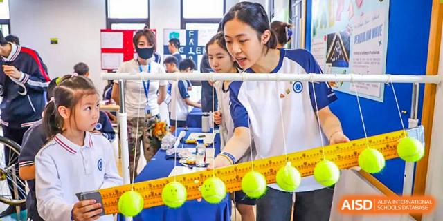 BASIS International School Nanjing students working on a science experiment involving balls and a rod.