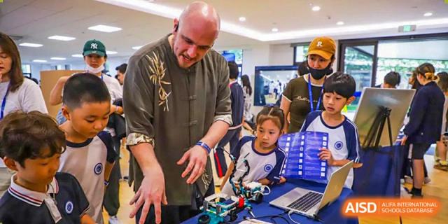 An adult helping a young BASIS International School Nanjing student with a project.