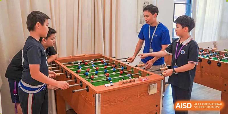 BASIS International School Nanjing students playing foosball in a recreational area.