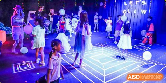 BASIS International School Nanjing students playing on a lit dance floor.