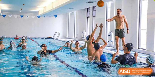 BASIS International School Nanjing students playing with a ball in a swimming pool.