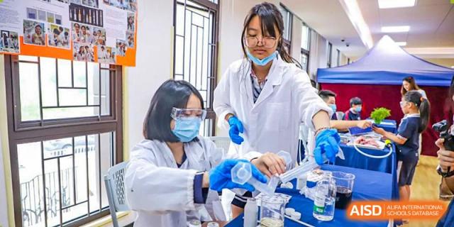 BASIS International School Nanjing students in lab coats are performing a science experiment.