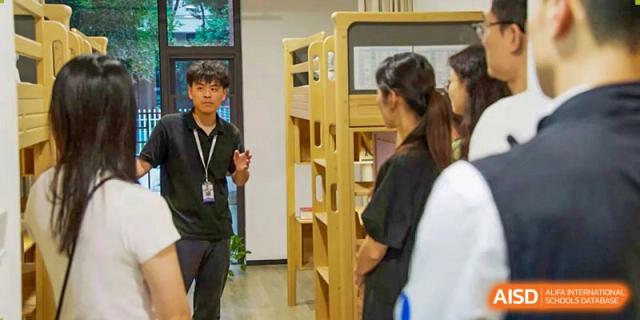 A BASIS International School Nanjing student is helping another student in a library or study area.