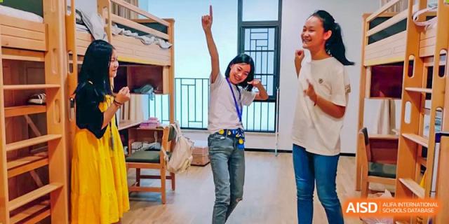 A BASIS International School Nanjing student is cheering excitedly with their arm raised.