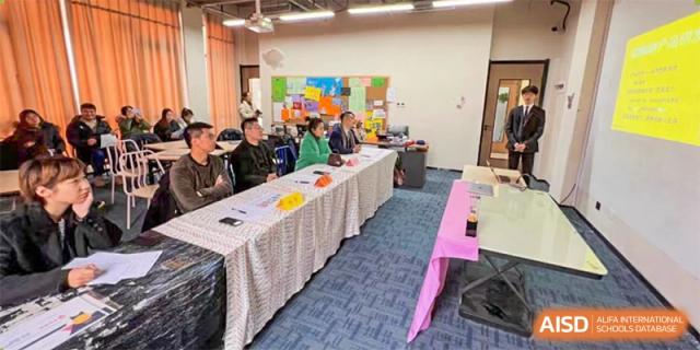 Vindu-Charlie Lakefield College students and staff seated around a long table covered in a white cloth, participating in a group meeting or workshop.
