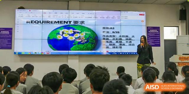 Students watch a presentation screen showing a diagram of the Earth and project requirements in Chinese characters during a lesson at Vindu-Charlie Lakefield College.