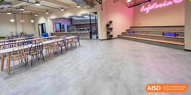 A wide view of the modern, brightly lit cafeteria or dining hall space at Vindu-Charlie Lakefield College.