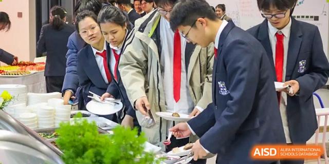 Students and adults serve themselves food from a buffet line during a formal event at Vindu-Charlie Lakefield College.