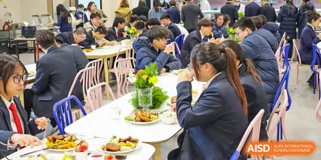 An adult guest enjoys a meal seated at a table with a centerpiece during an event at Vindu-Charlie Lakefield College.