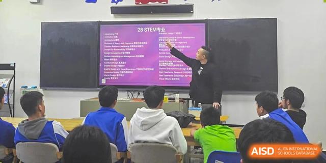 A student from The High School Attached to Hunan Normal University pointing to a slide about 2B STEM during a presentation to classmates.