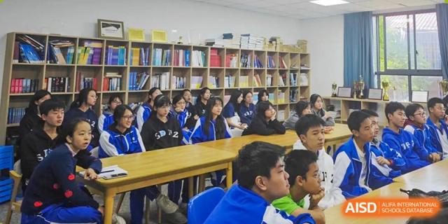 Students from The High School Attached to Hunan Normal University studying or attending a class in the school library, surrounded by bookshelves.
