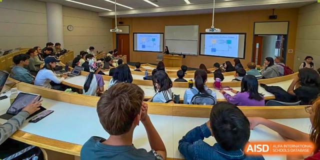 A view from the back of the class showing Wenzhou Union International School (WUIS) students watching a lesson on a large screen in a classroom.