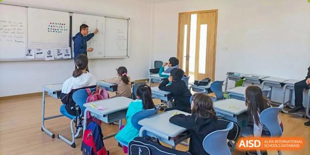 Wenzhou Union International School (WUIS) students seated at individual desks working on assignments in a bright, modern classroom.