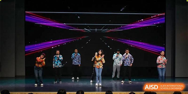 A student from the CNUH-GA Curriculum Partnership Program performing a solo vocal or musical number on a dark stage with a dynamic light display.