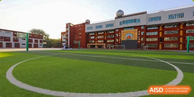 The CNUH-GA Curriculum Partnership Program campus building overlooking an artificial turf sports field and running track.