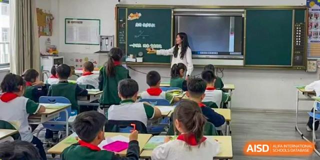 Yancheng Foreign Language School students engaged in a lesson, sitting at their desks while a teacher instructs.