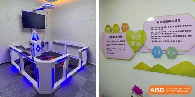 An interior photo showing a hallway with blue lighting near a barrier and a sign on a wall, likely within Yancheng Foreign Language School.